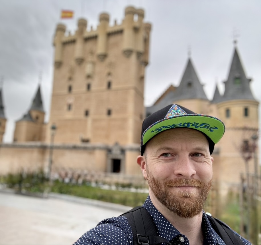 Robbie Henry-Keyes in a casual portrait with a castle in the background